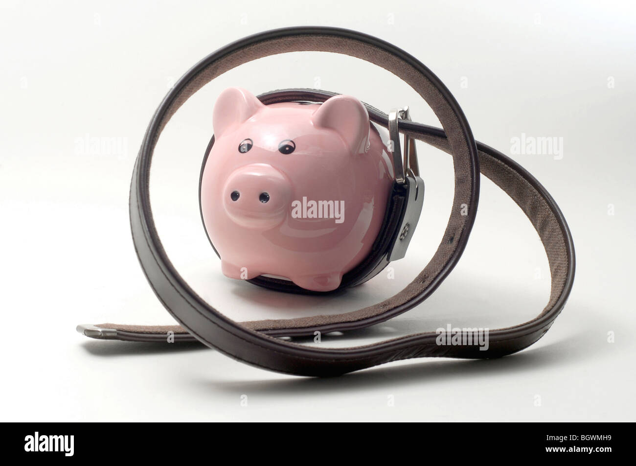 PIGGYBANK con cinghia di serraggio attorno RE economica spremere la tensionatura della cinghia,DEBITO,debiti,i bilanci dei salari dei redditi il denaro economia UK Foto Stock