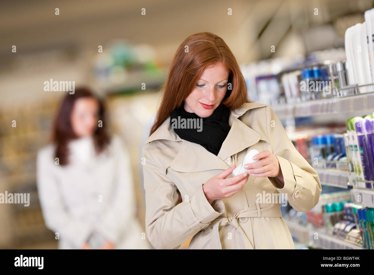 Shopping - capelli rossi donna deodorante di acquisto in un reparto cosmetico Foto Stock