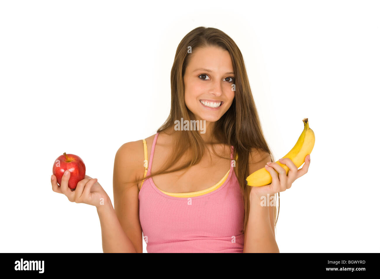 La donna caucasica tenendo una mela e una banana cercando di decidere che uno a mangiare Foto Stock