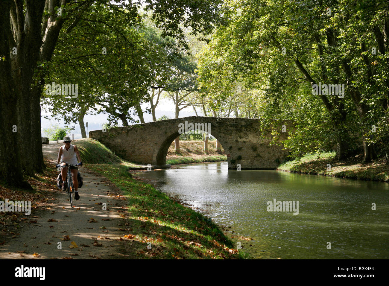 Donna bicicletta piccolo ponte Canal du Midi Trebes da Carcassonne Aude Francia Foto Stock