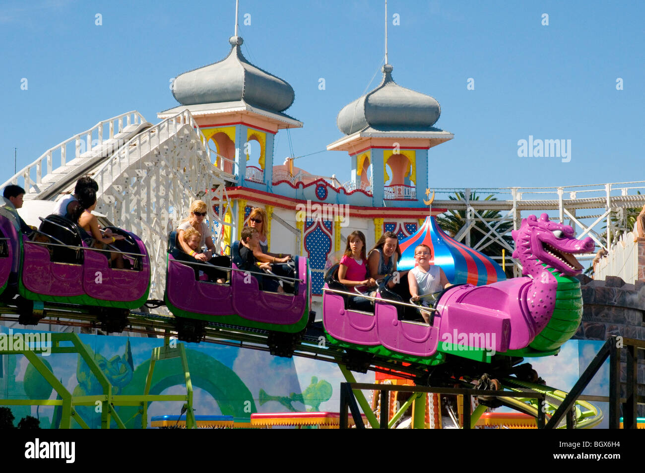 Equitazione il serpente stupido al Luna Park, St Kilda, Melbourne, Australia. Dietro il secolo-vecchia Ferrovia Scenica rollercoaster Foto Stock