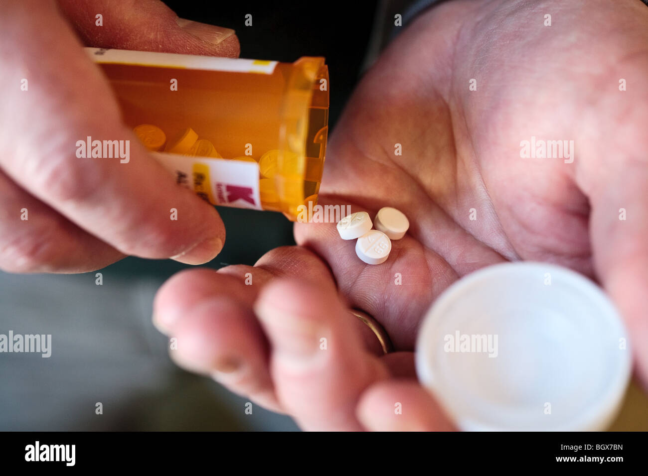 Una persona che toglie la prescrizione di farmaci da una bottiglia. Foto Stock