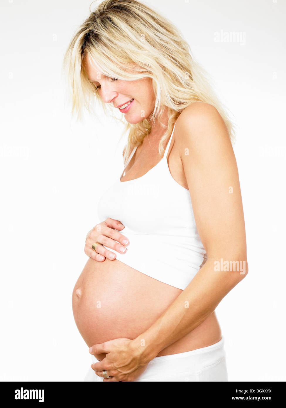 Donna incinta sorridente Foto Stock