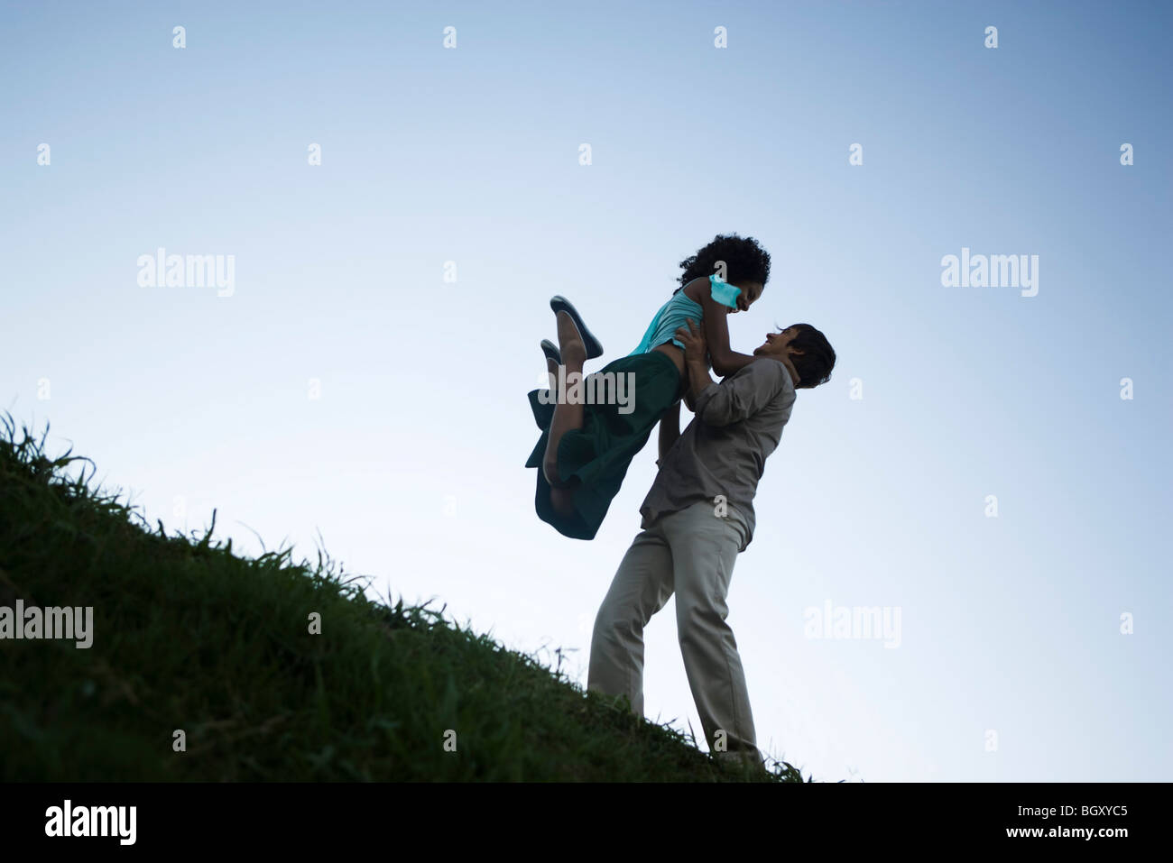 Coppia giovane, donna jumping in uomo di braccia Foto Stock