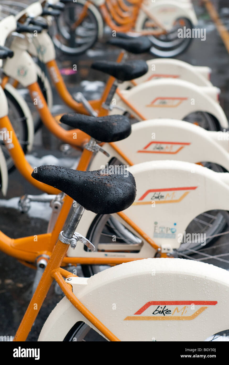 Biciclette pubbliche sotto la pioggia in strada, Milano, Italia Foto Stock