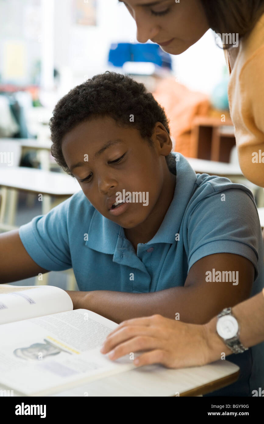 Aiutando l'insegnante di scuola elementare studente con incarichi Foto Stock