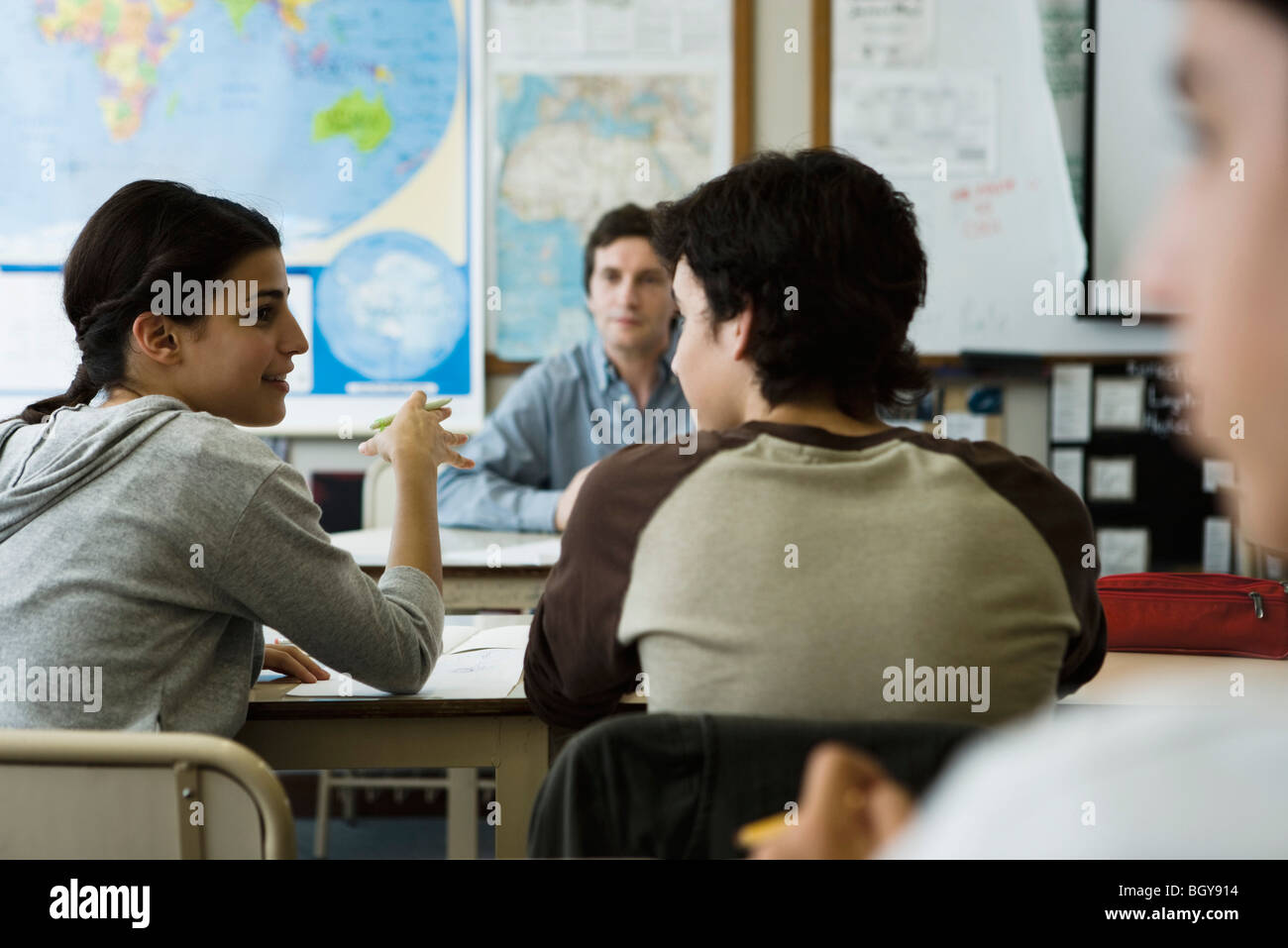 Studente di scuola superiore che parla con un compagno di classe in classe Foto Stock