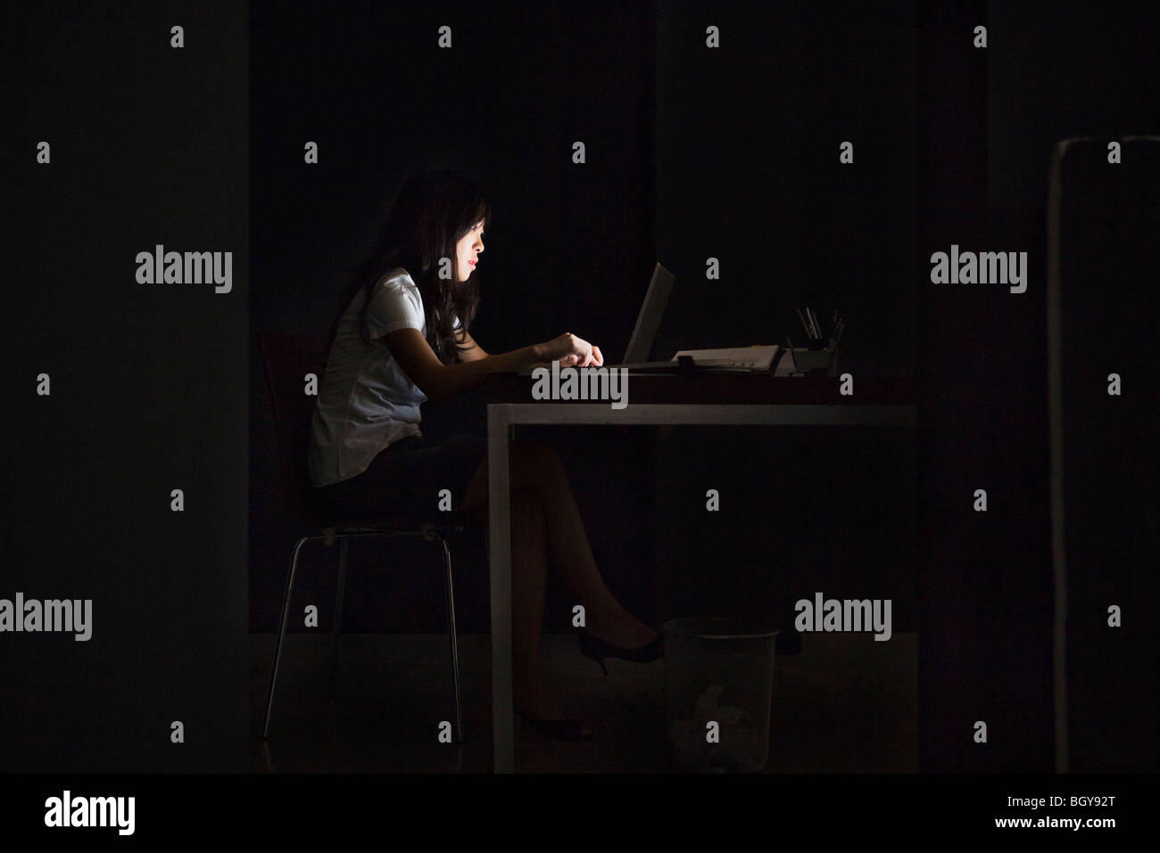 Donna in ufficio a lavorare in ritardo Foto Stock