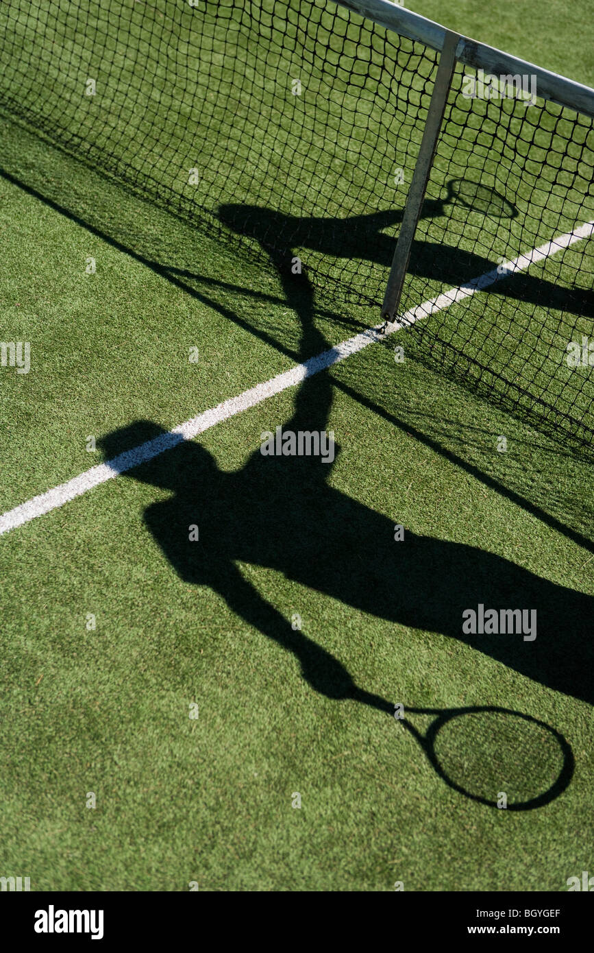 Ombra di giocatori di tennis stringono le mani su corte net Foto Stock