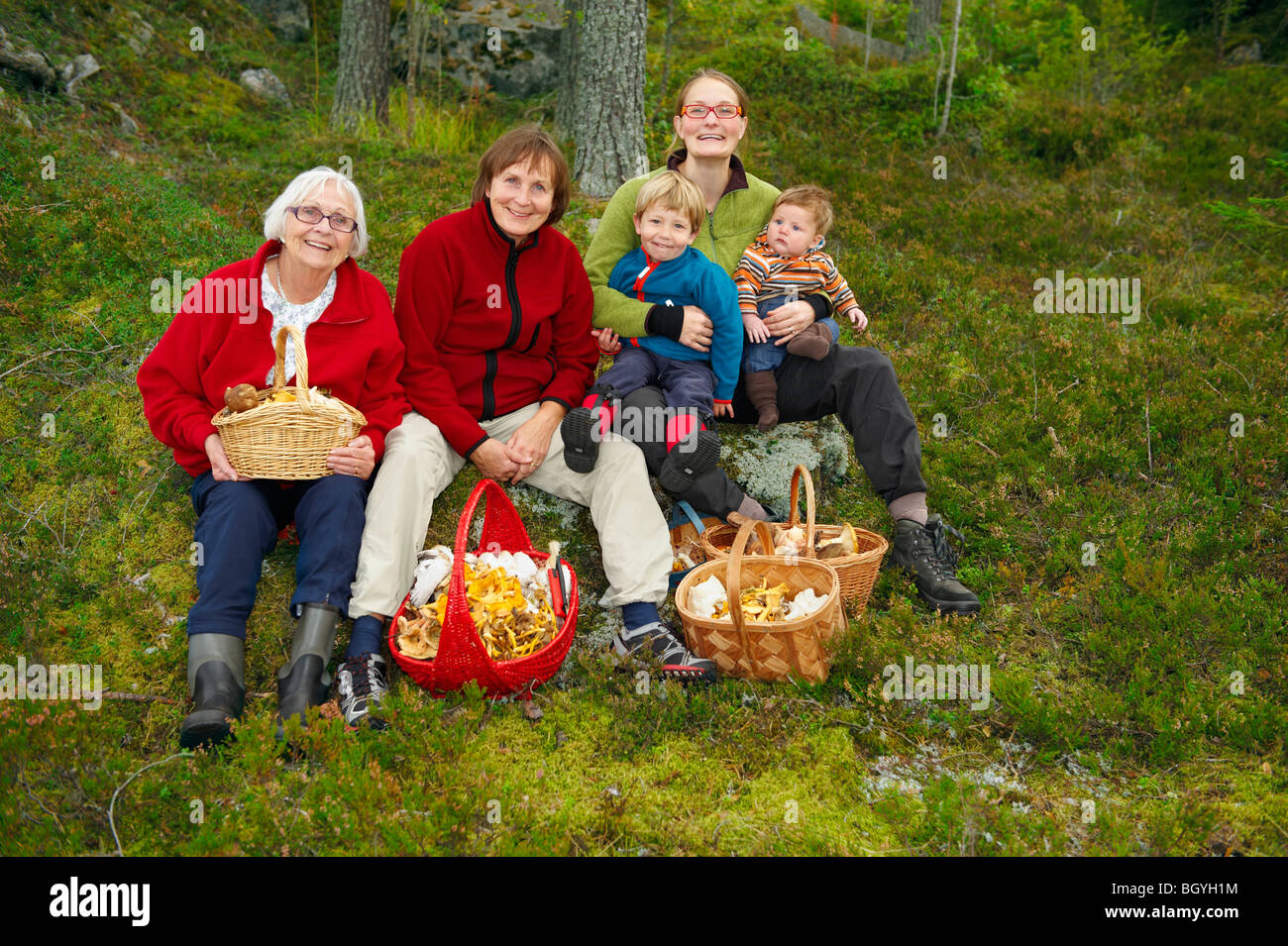 Famiglia con cestini di funghi nella foresta Foto Stock