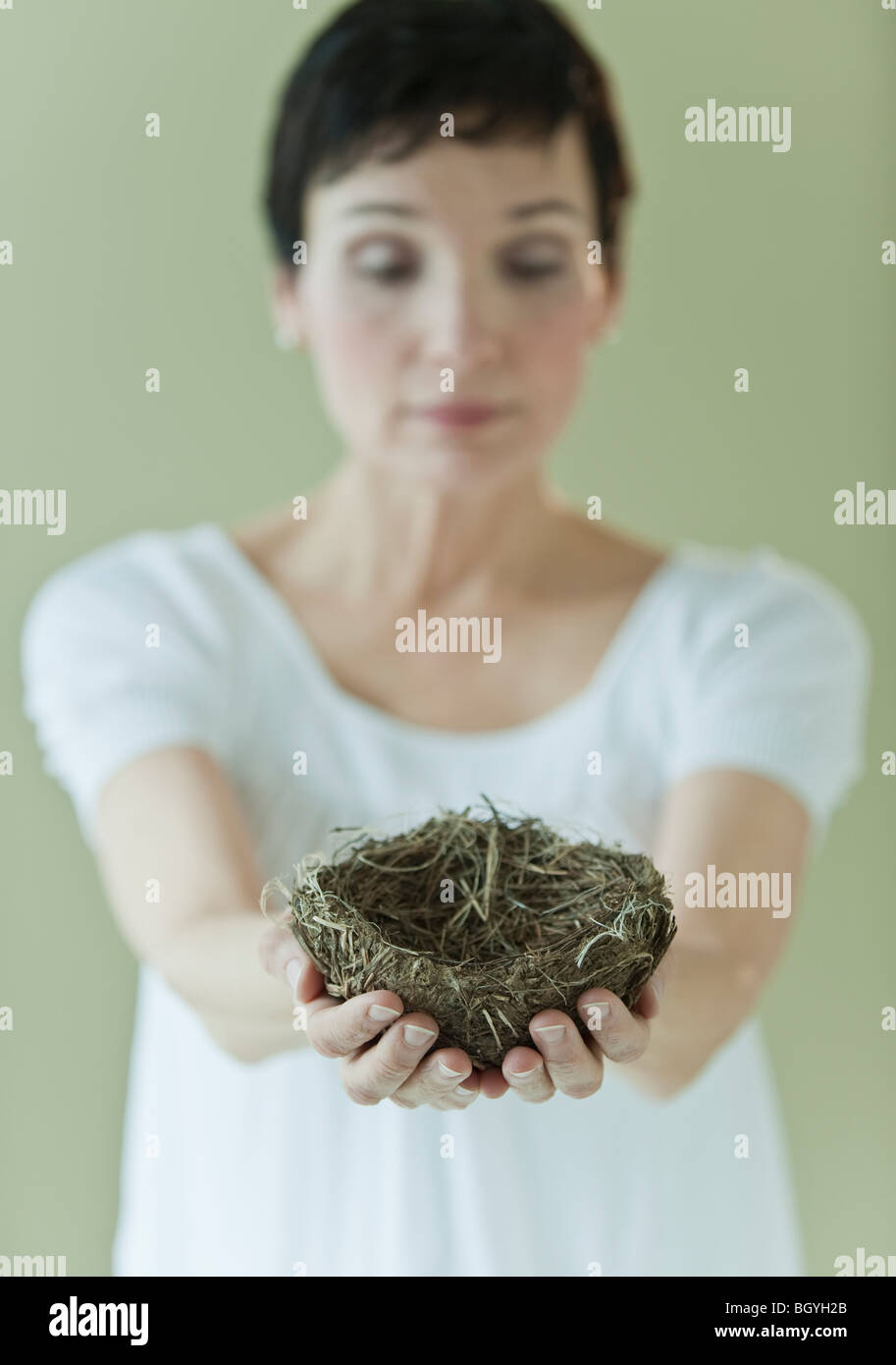 Donna che mantiene nest Foto Stock
