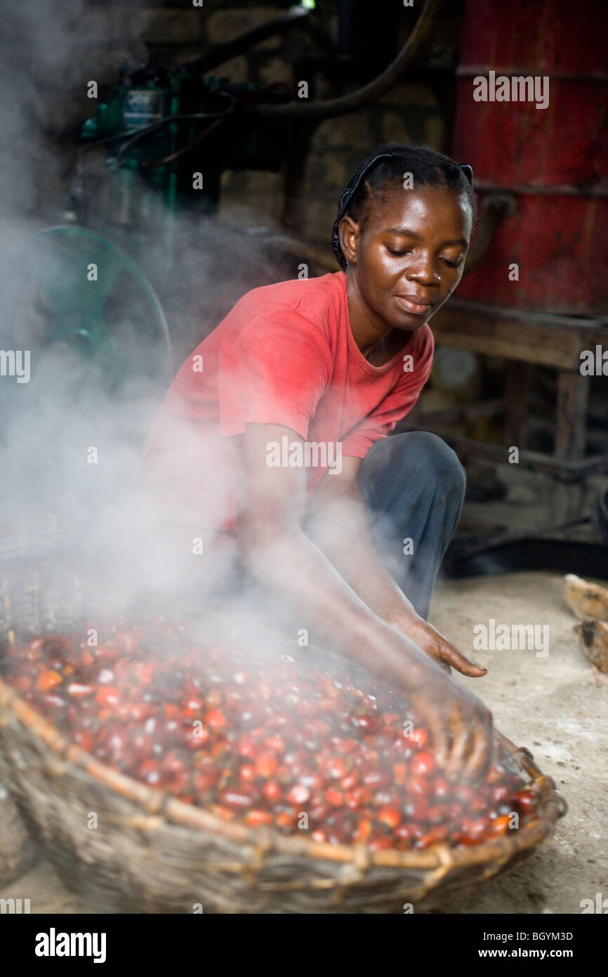 Agricoltore operante per la cottura a vapore di olio di palma Foto Stock