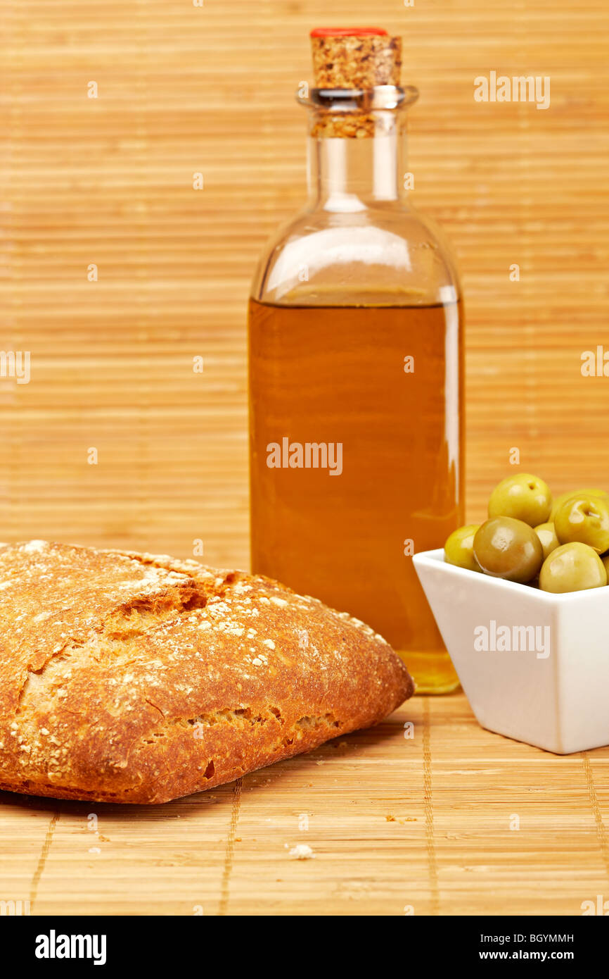 Pane e olio di oliva Bottiglia e alcune olive su sfondo di legno. Profondità di campo Foto Stock