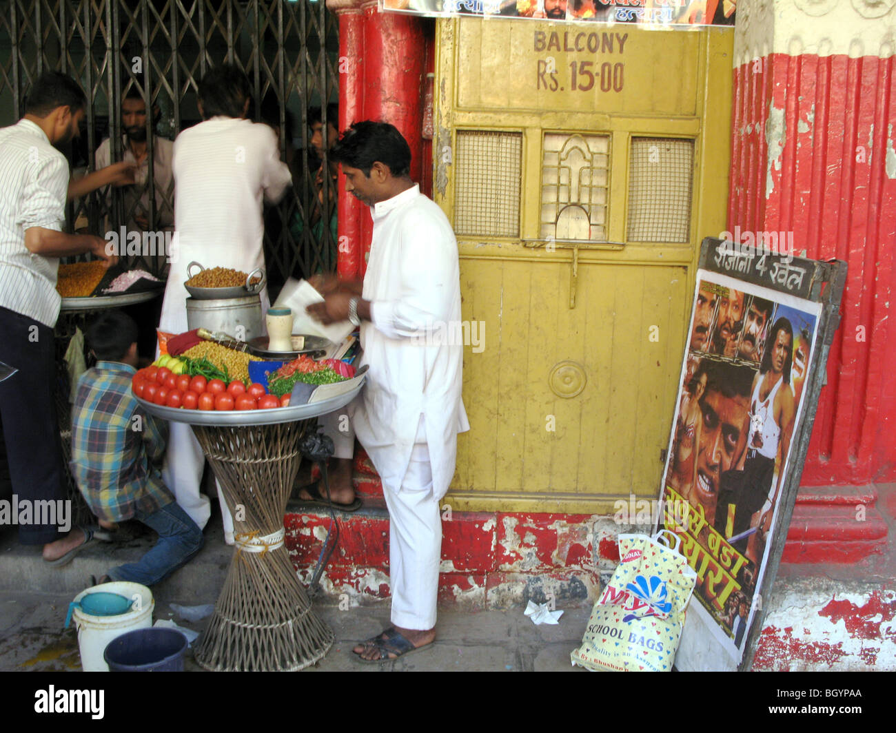 INDIA. Persone che acquistano snack durante un intervallo in una vecchia foto casa a Mumbai fotografia © Julio Etchart Foto Stock