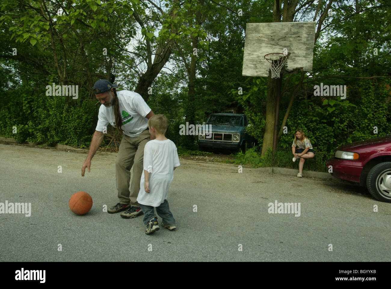 Contrassegnare Haggerty, che è un veterano del Vietnam e un attivista politico, gioca a basket con Landon Hivner, 6, vicino al Crestmont Sec Foto Stock