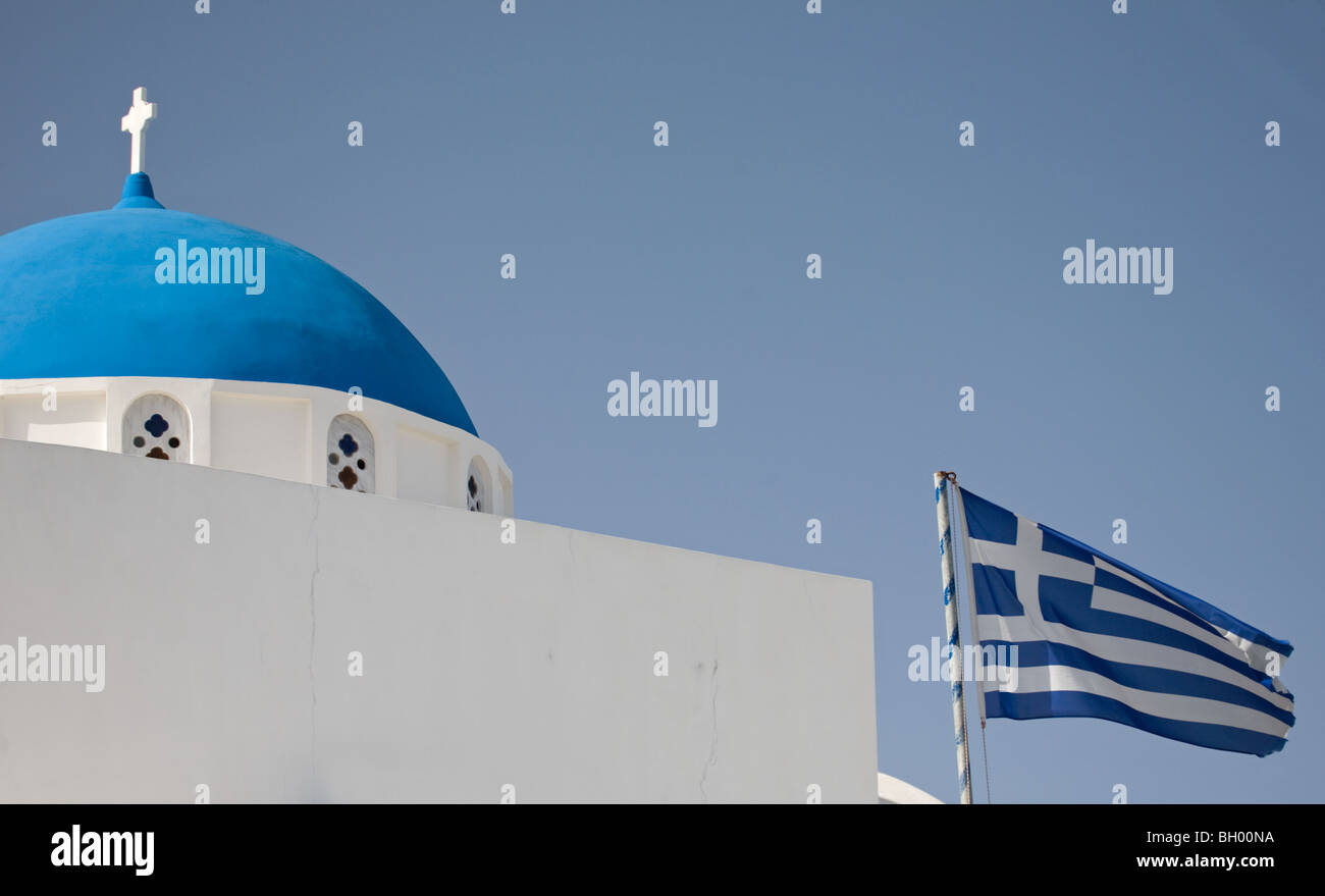 Bandiera greca e chiesa con cupola blu a Imerovigli sull'isola di Santorini, Grecia Foto Stock