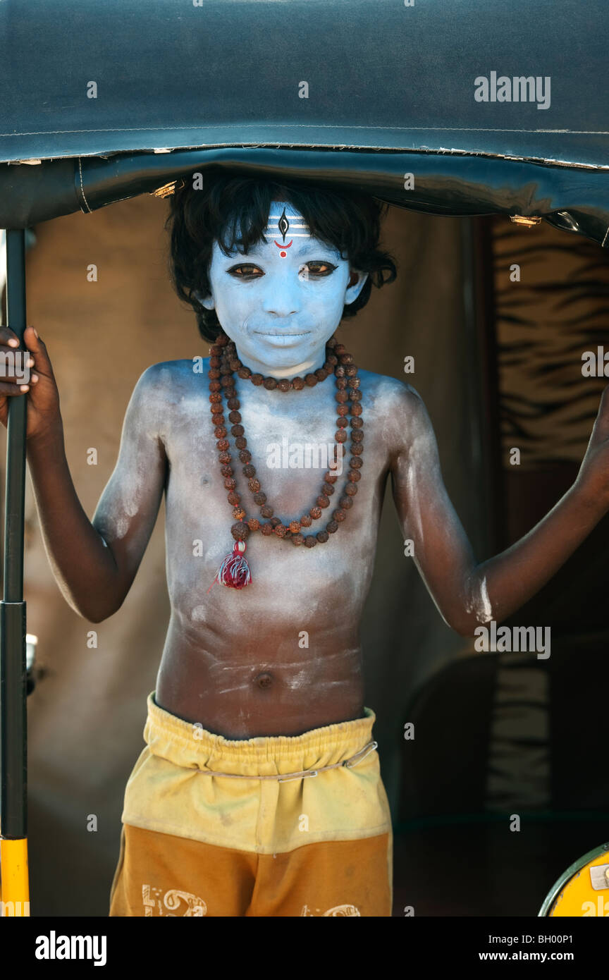 Ragazzo indiano, faccia dipinta come il dio indù Shiva in piedi in un rickshaw. Andhra Pradesh, India Foto Stock