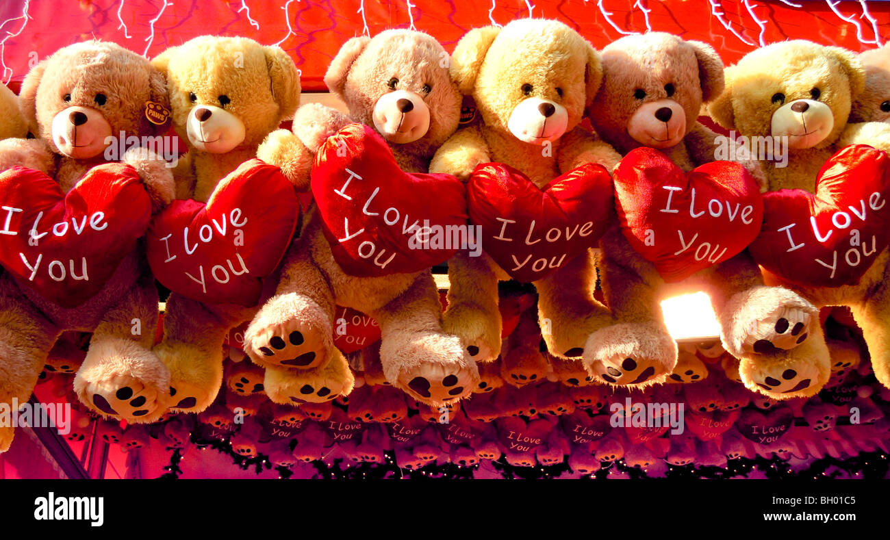 Toy orsetti holding rosso brillante cuori con le parole TI AMO su di essi Foto Stock
