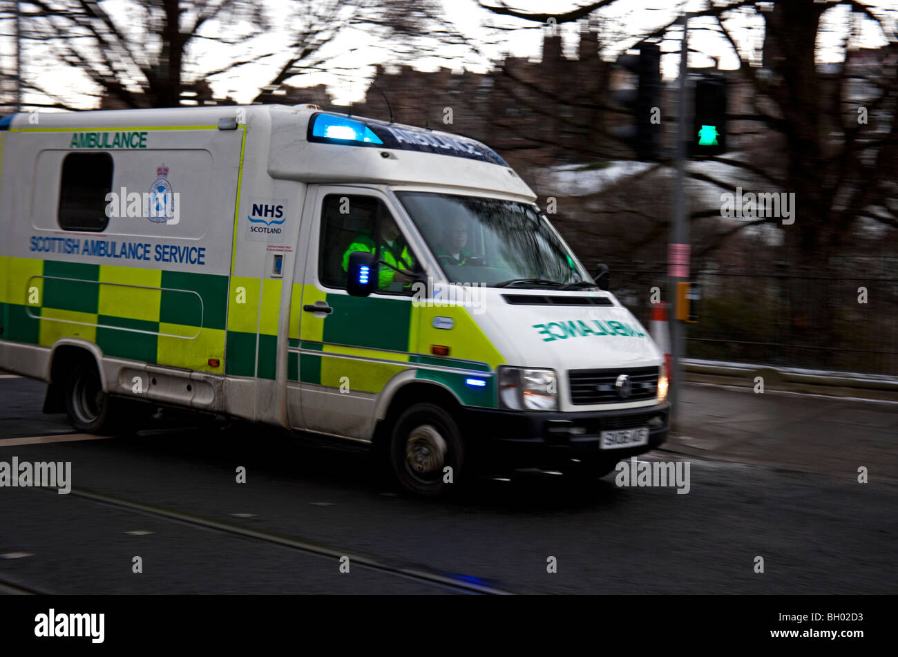 Scottish servizio ambulanza che viaggia a velocità su e di chiamata di emergenza con luci blu lampeggiante, Edimburgo in Scozia Foto Stock
