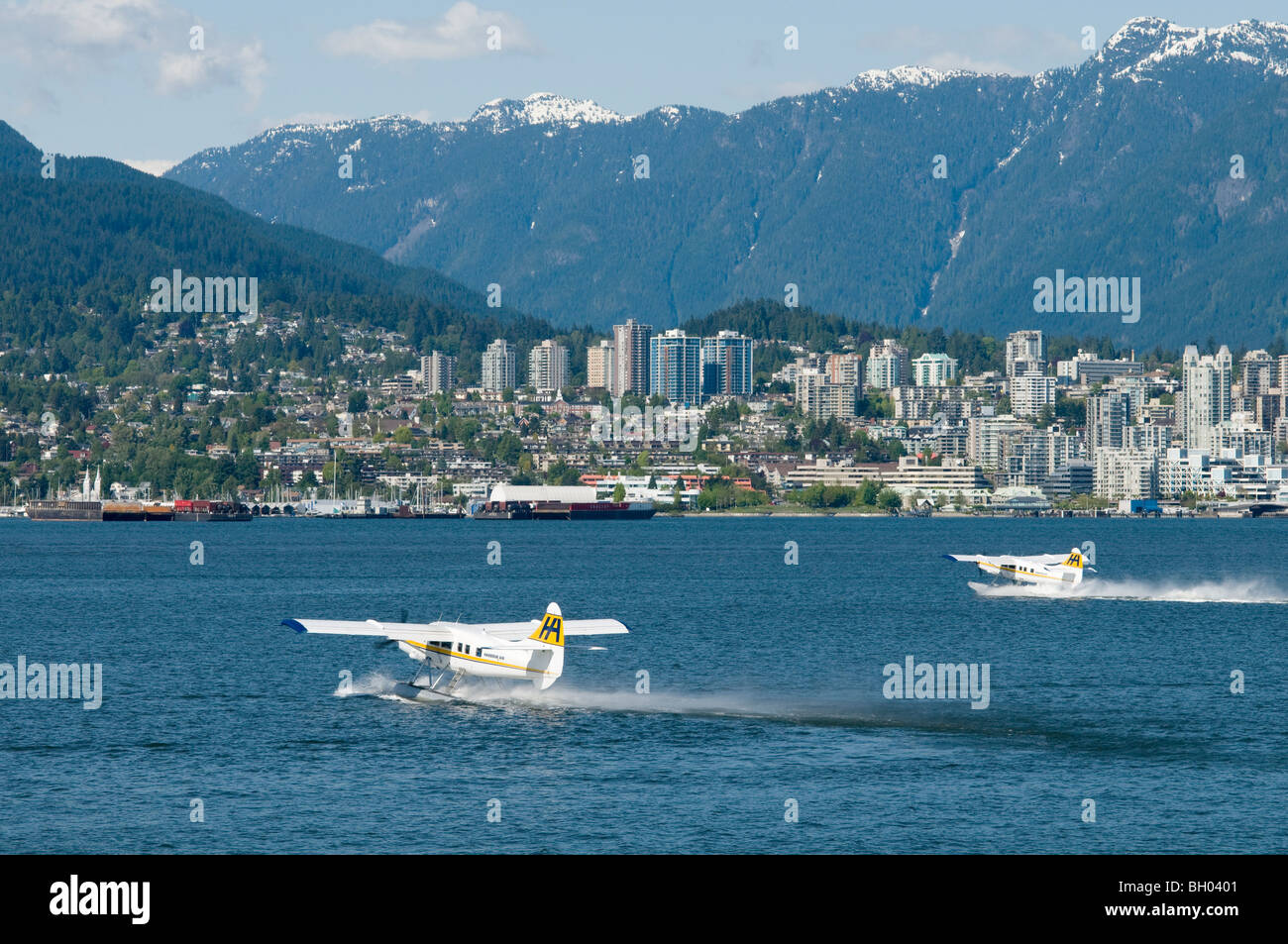 Due dei " commuters " Piani di flottazione di decollare con il Porto di Vancouver, Vancouver, Canada Foto Stock