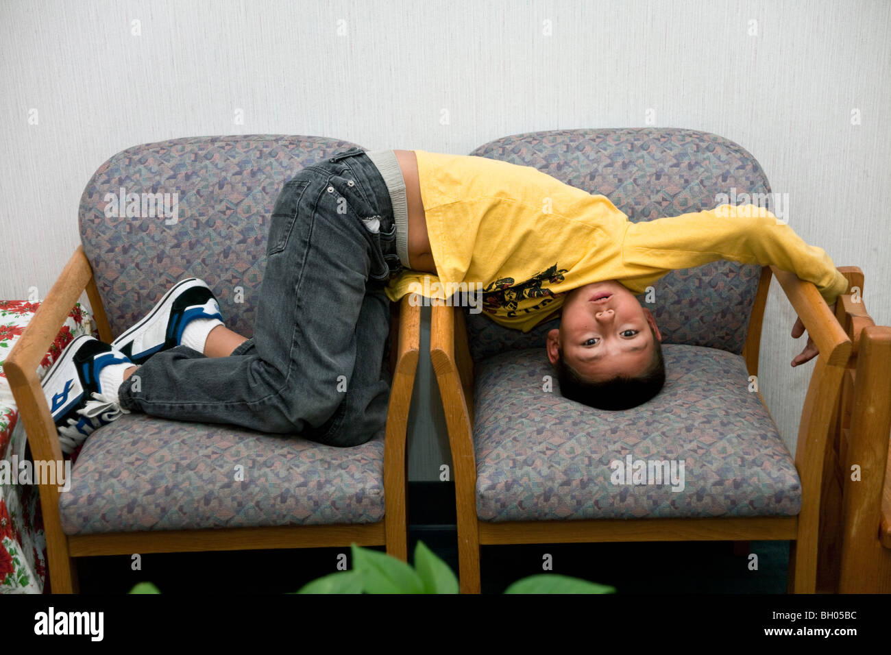 Otto anni ragazzo ispanico attesa per il suo appuntamento con il medico. Signor © Myrleen Pearson Foto Stock