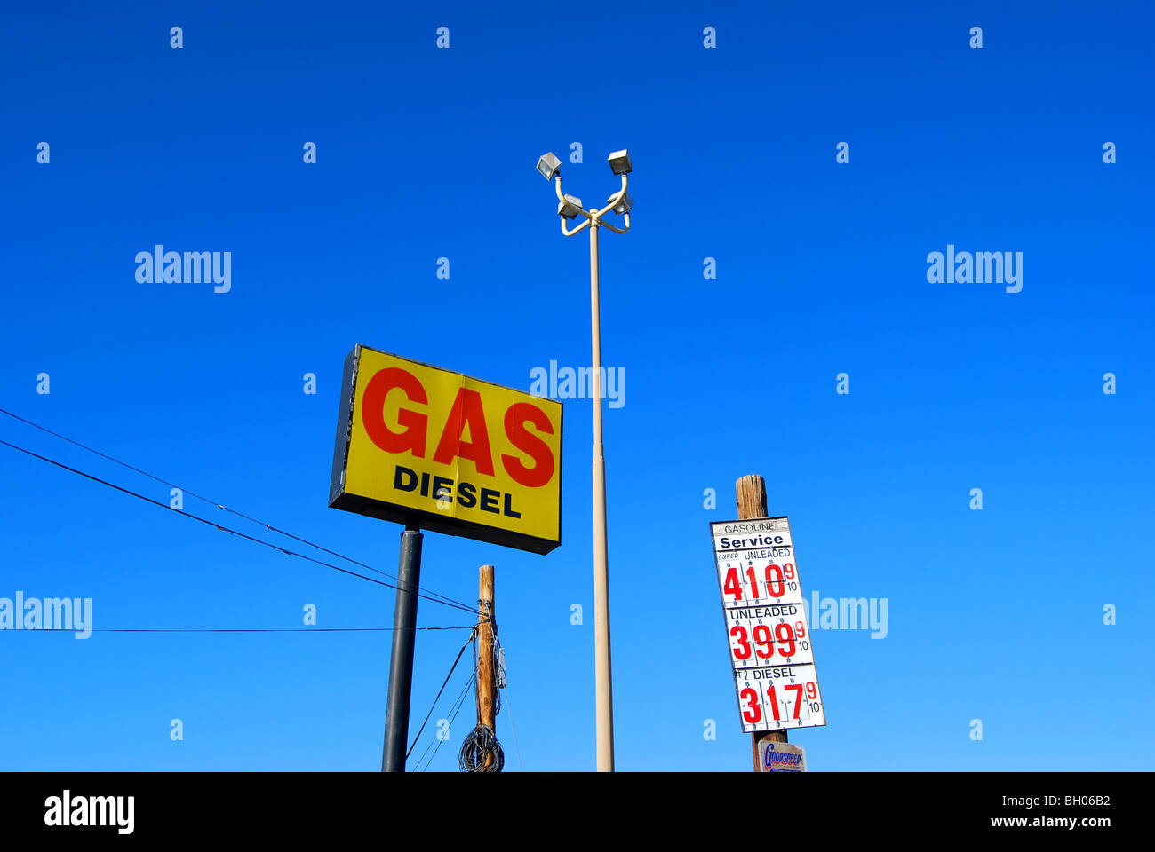 Gas e gasolio firmare con il polo elettrico e firmare con i prezzi del gas e un vecchio palo del telefono Foto Stock