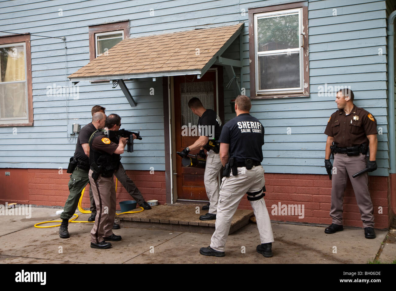 Sheriff's Office deputati che serve in materia di lotta contro la droga di un mandato di perquisizione. Foto Stock