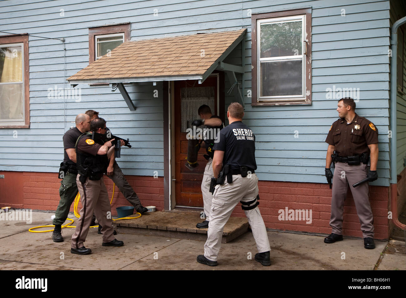 Sheriff's Office deputati che serve in materia di lotta contro la droga di un mandato di perquisizione. Foto Stock