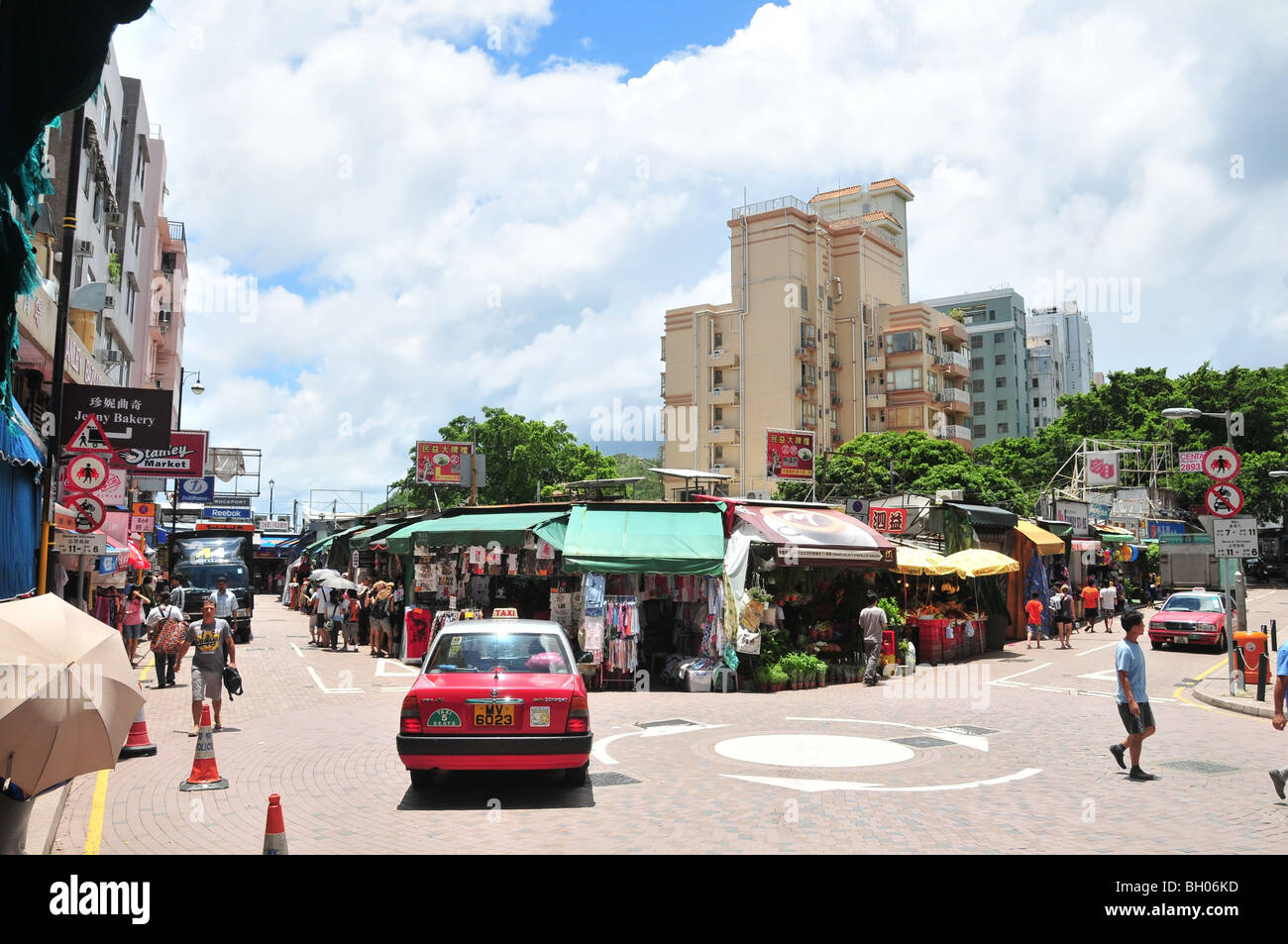 Aria aperta negozi, cartelli pubblicitari, gli acquirenti, i taxi e i furgoni in corrispondenza di un nodo stradale presso il Mercato Stanley, Hong Kong, Cina Foto Stock