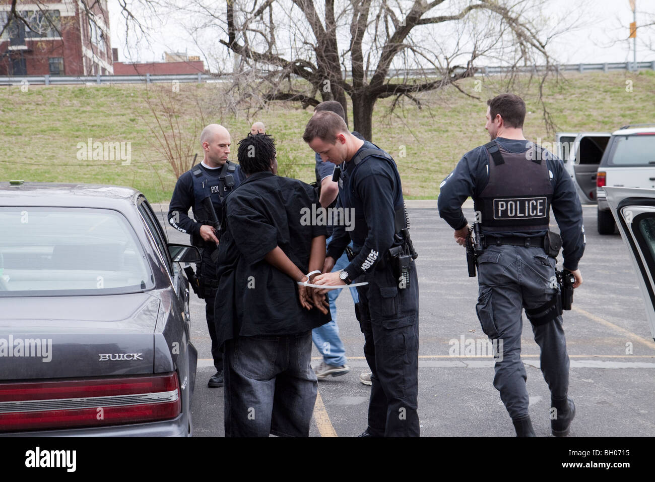 Funzionari di polizia da le tattiche di squadra di strada Unità narcotici interrogando il sospetto. Kansas City, MO, PD. Foto Stock