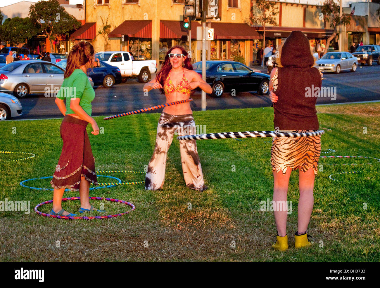 Felice hula hoop appassionati di tenere un 'Hoopnosis' sessione nel tardo pomeriggio di sole sulla spiaggia principale in Laguna Beach, CA. Foto Stock