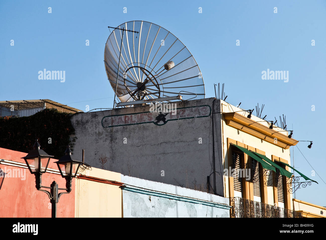 Giant parabola satellitare contro un puro cielo blu sul tetto di un ristorante in una giornata di sole nella città di Oaxaca Messico Foto Stock