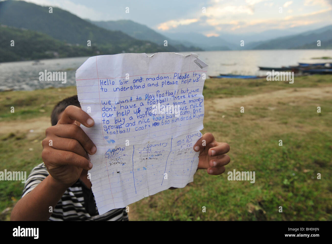 L'Asia, il Nepal, il giovane ragazzo in attesa di una lettera con un appello per i soldi per comprare un calcio Foto Stock