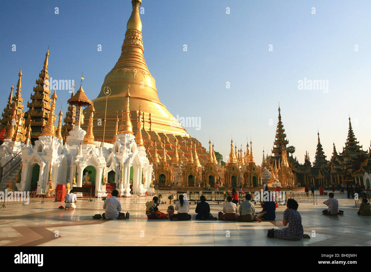 Pregando buddisti alla Shwedagon pagoda in luce del sole di sera, Rangoon, MYANMAR Birmania, Asia Foto Stock