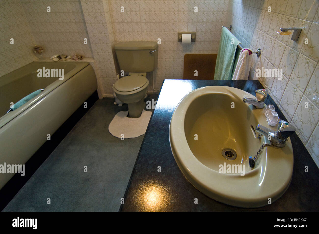 Orizzontale di ampio angolo interno di un vecchio 80's bagno con un colore verde suite bagno. Foto Stock