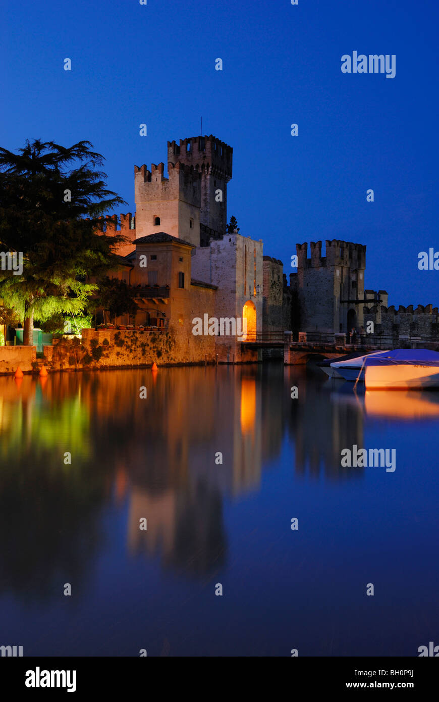 La riflessione di illuminata Castello Scaligero del lago di Garda, Sirmione, Lombardia, Italia Foto Stock