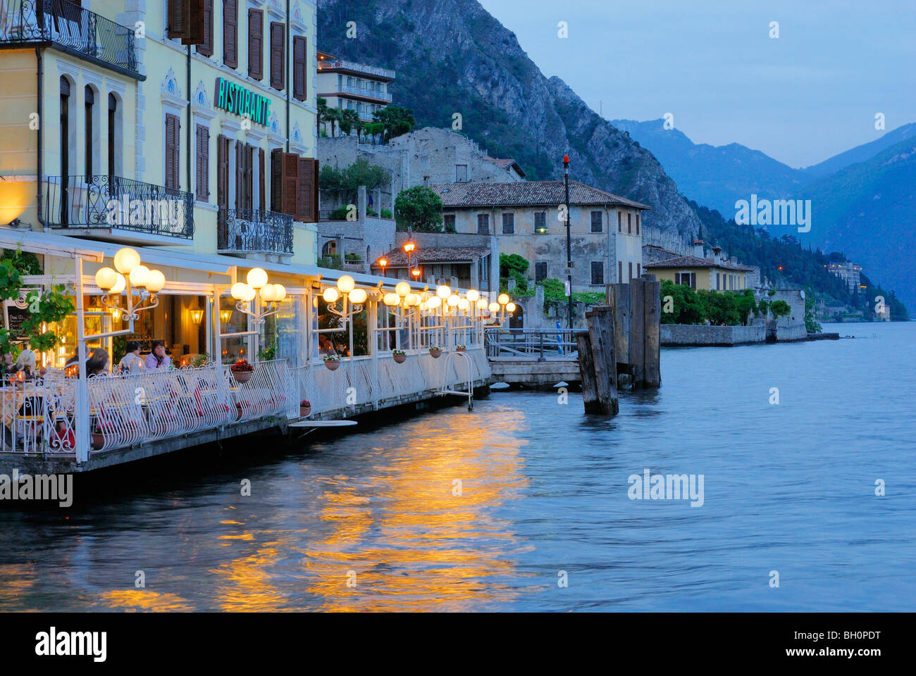 Terrazza illuminata di un ristorante in riva al lago di Garda Limone sul Garda, Lombardia, Italia Foto Stock