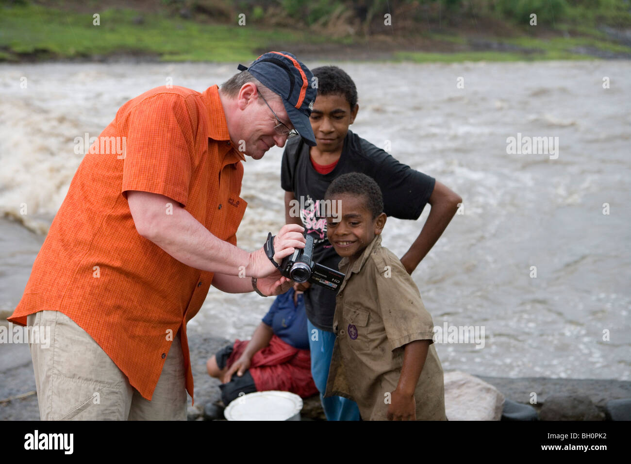 Tourist mostrando le immagini sulla sua videocamera per ragazzi Fijiano, Navala, Viti Levu, Isole Fiji, South Pacific Oceania Foto Stock