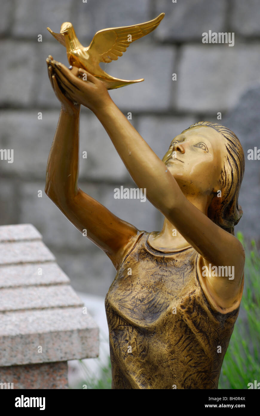 Statua di una giovane donna di rilasciare una colomba della pace, statua in bronzo, Brissago, Lago Maggiore, Lago Maggiore, Ticino, Svizzera Foto Stock