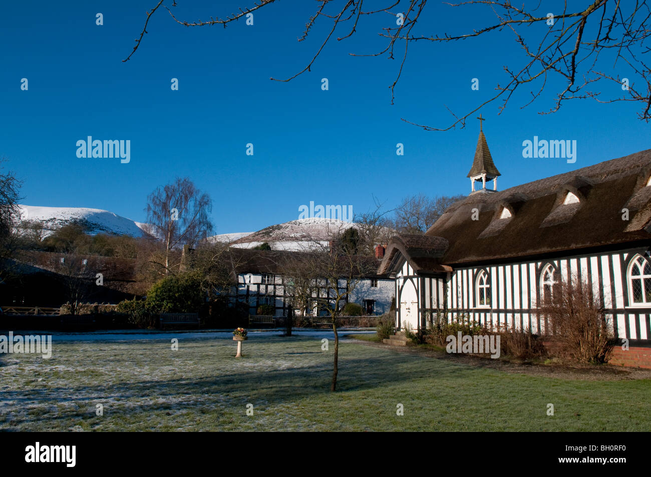 Tutti chiesetta, Little Stretton, Shropshire, in inverno con il Longmynd in background Foto Stock