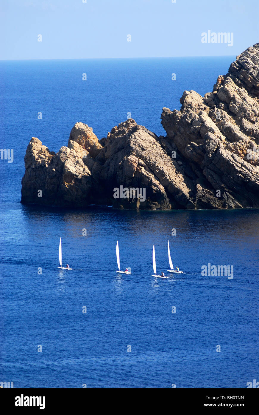 Barche a vela da una scuola di vela da Fornells a Cap de Fornells, Minorca, Isole Baleari, Spagna Foto Stock