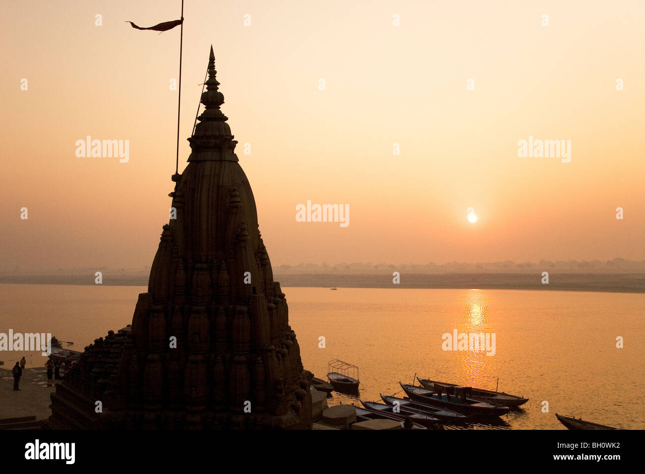 Il sole sorge oltre la Ganga (Gange) river a Varanasi, India Foto Stock