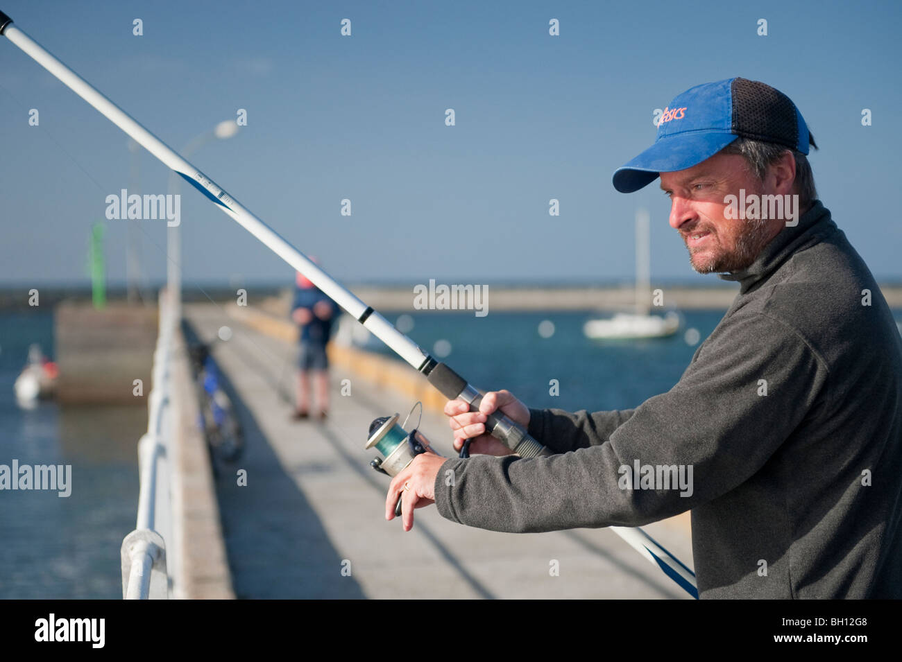 Close up di un uomo di pesca in mare al largo del porto a parete Kerity, vicino Penmarc'h, Bretagna meridionale Foto Stock