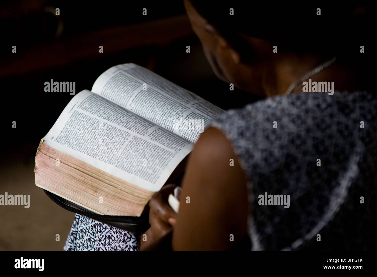 Donna della lettura della Bibbia durante il servizio in chiesa in Uganda, Africa Foto Stock