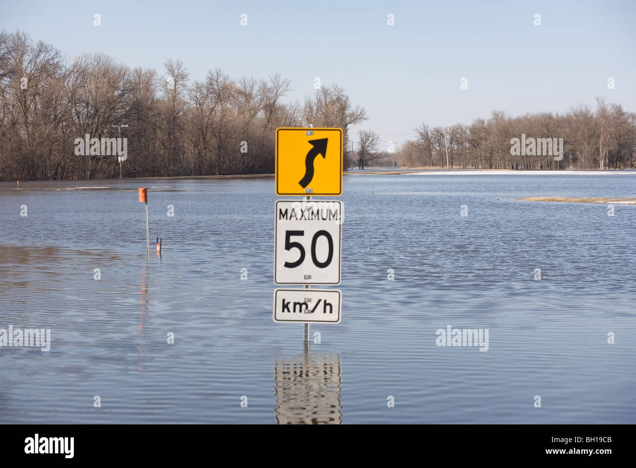Cartello stradale sulla strada che è coperto con inondazione dal Fiume Rosso, Manitoba, Canada Foto Stock