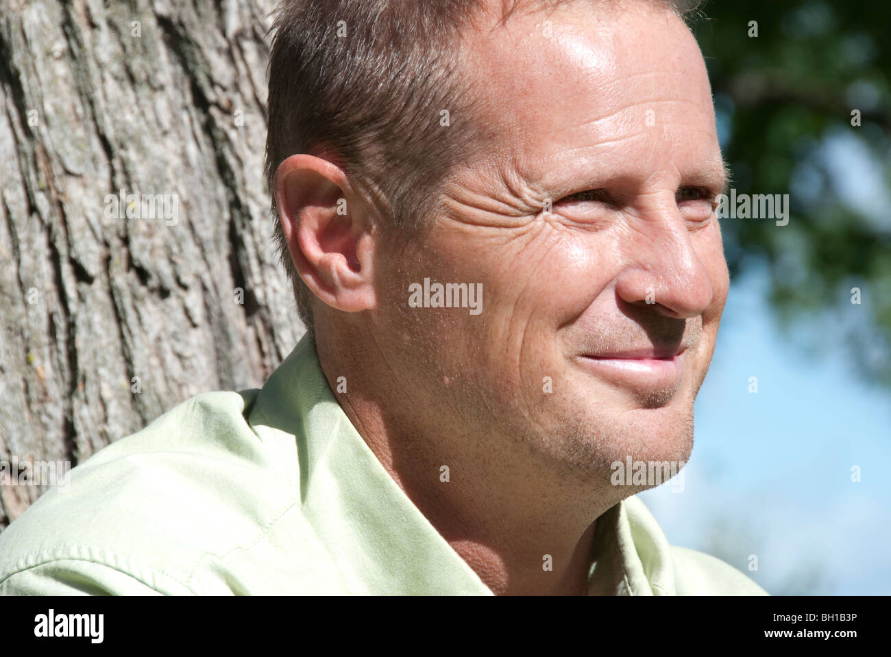 Ritratto dell uomo nella sua 40's accanto all albero, Assiniboine Park, Winnipeg, Manitoba, Canada Foto Stock