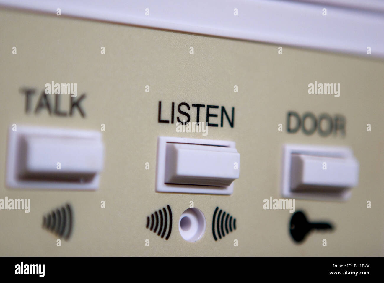 Primo piano di un sistema di cicalino della portiera in cui "ascoltare" è la parola principale mostrata. Foto Stock