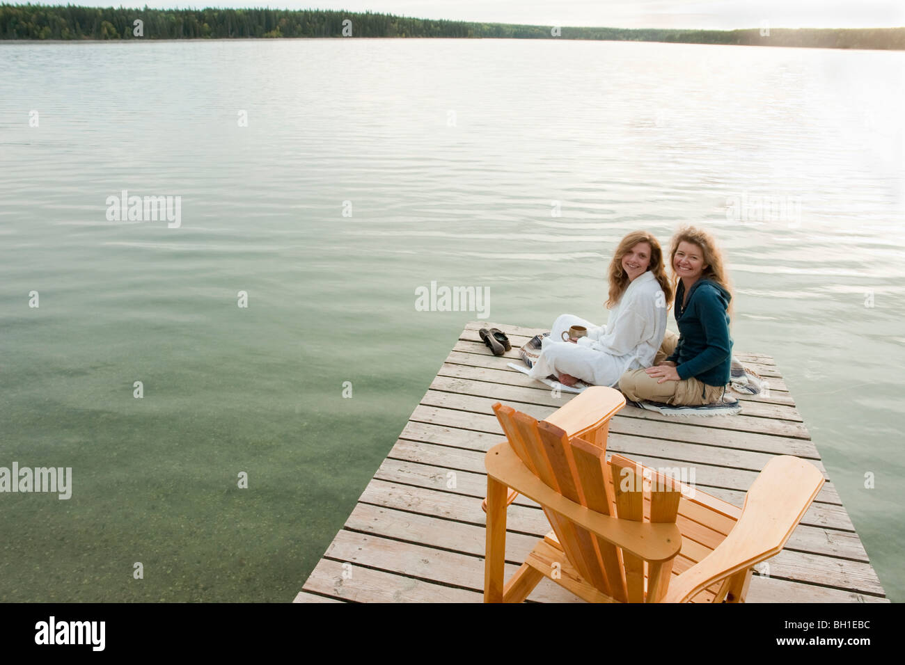 Traino di donne seduti sul dock, Clear Lake, Manitoba, Canada Foto Stock