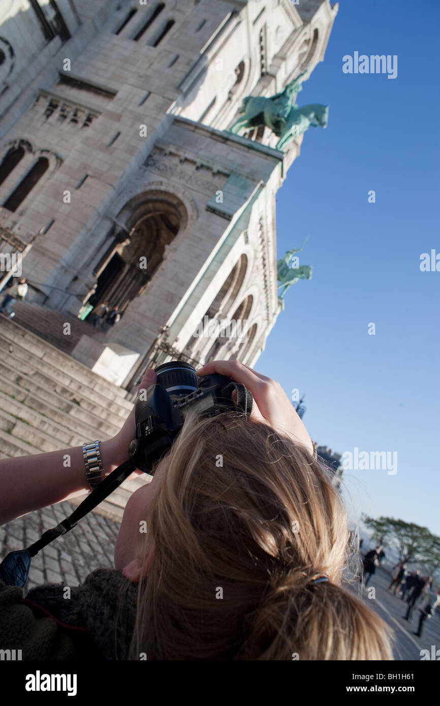 Un turista femminile è scattare una fotografia del Sacre Coeur a Parigi Foto Stock