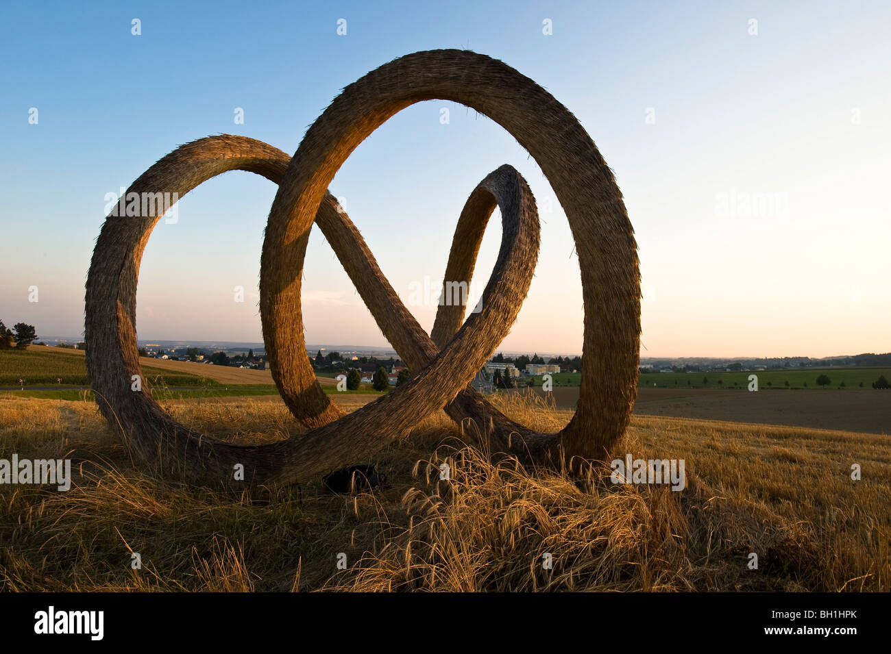 Scultura fatta di paglia su un campo al crepuscolo, Linz, Austria superiore, Austria Foto Stock